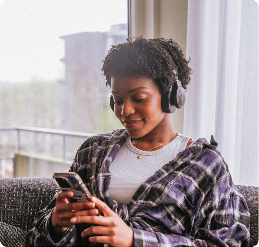 Vrouw op de foto waarbij ze luisterd naar muziek en op haar telefoon kijkt
