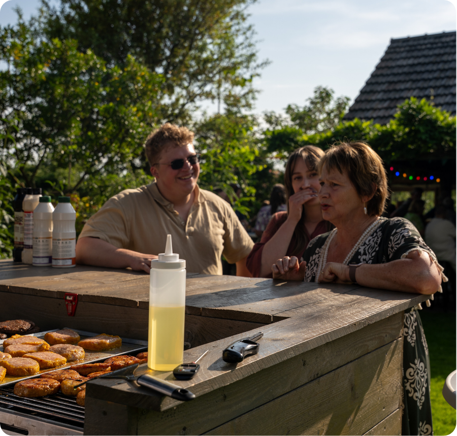 Mensen die aan het wachten zijn tot hun vlees van de bbq afkomt en dat dit moment gefotografeerd is